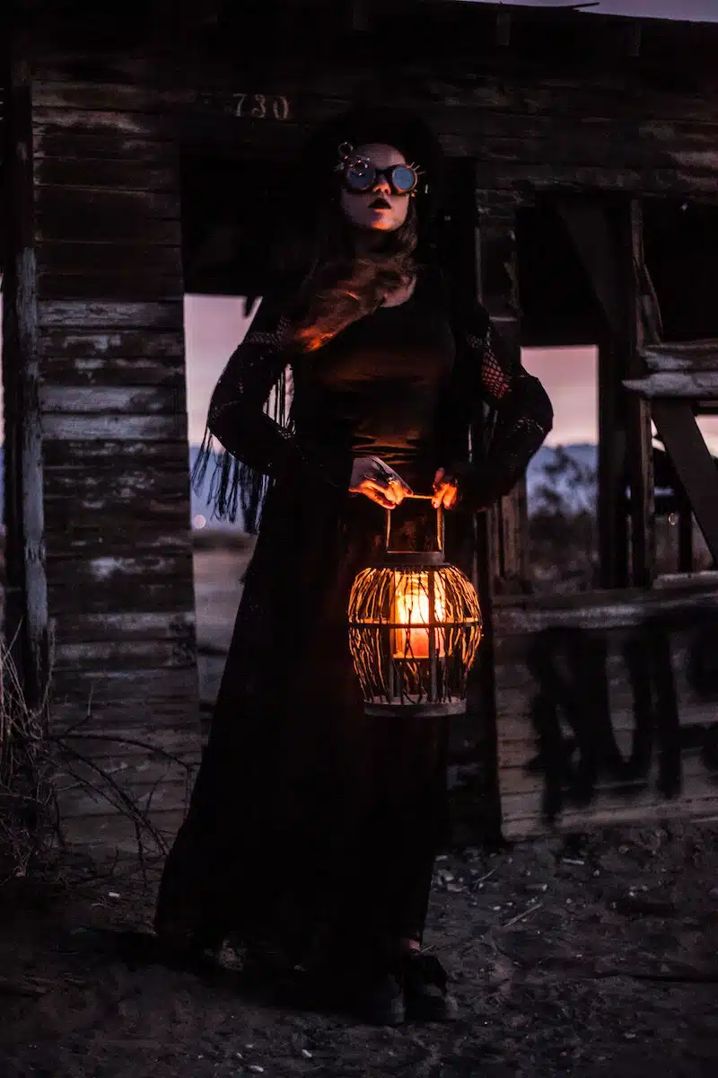 A Woman in a Steampunk Outfit Holding a Lamp